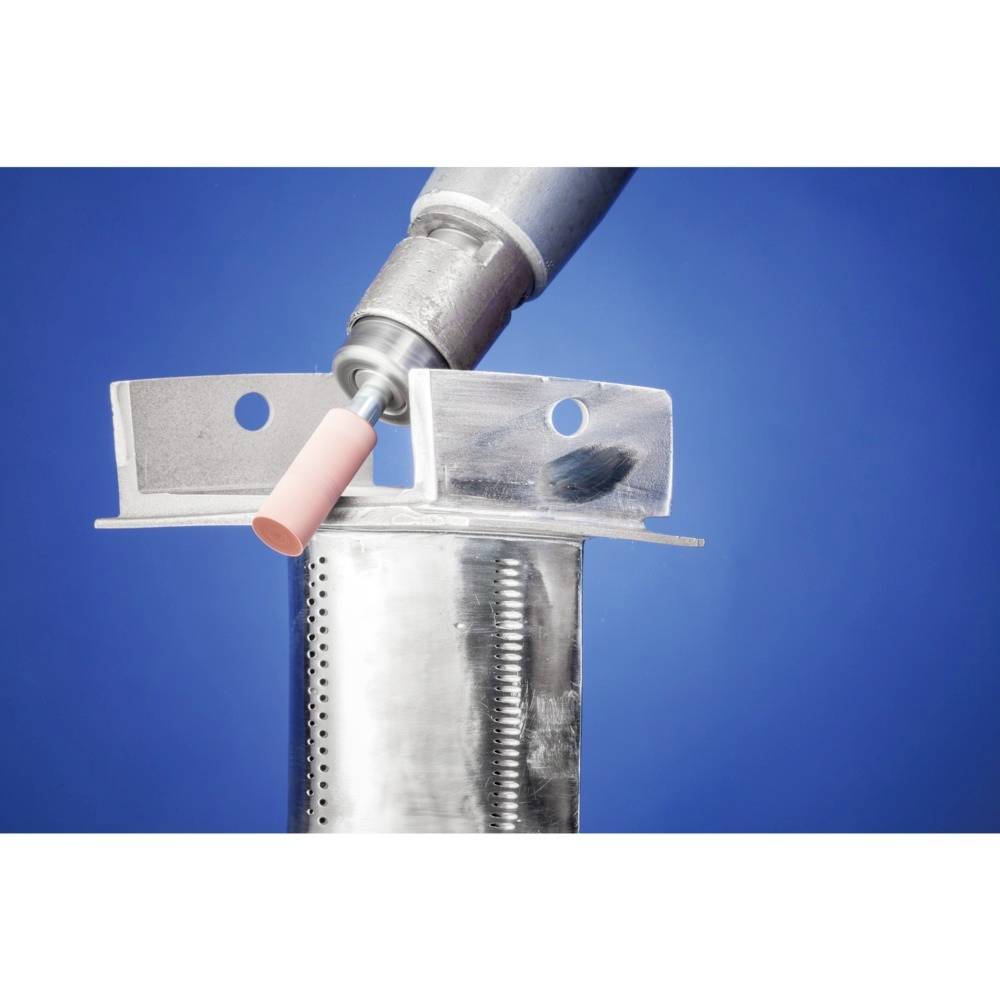 Ein Metallpolierwerkzeug berührt die Kante eines perforierten Metallstücks, vor blauem Hintergrund.