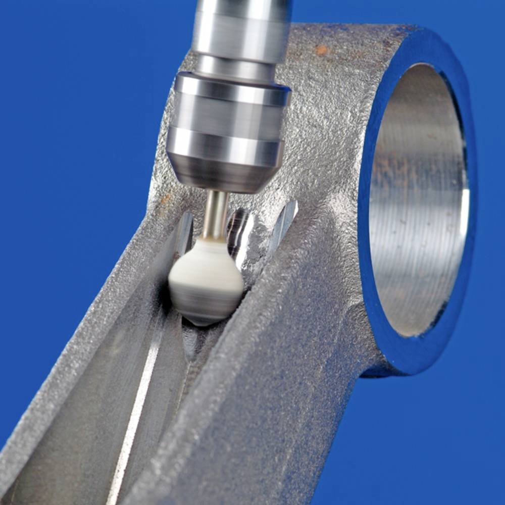 Eine Fräsmaschine bearbeitet präzise eine Metalloberfläche. Der Fokus liegt auf der Drehbewegung des Fräskopfes und der glatten Metalloberfläche.
