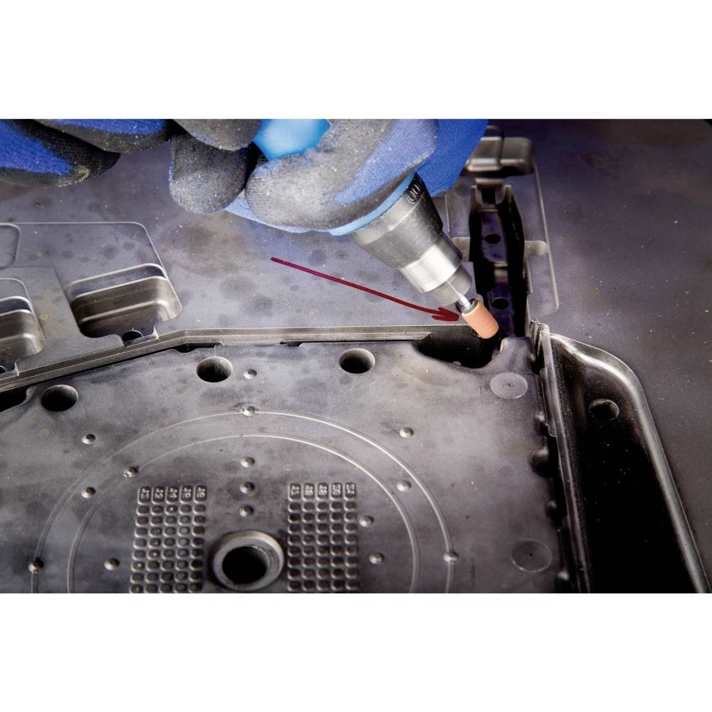 Eine Hand mit einem blauen Handschuh verwendet ein Werkzeug, um eine Schweißnaht an einem Metallteil zu setzen.