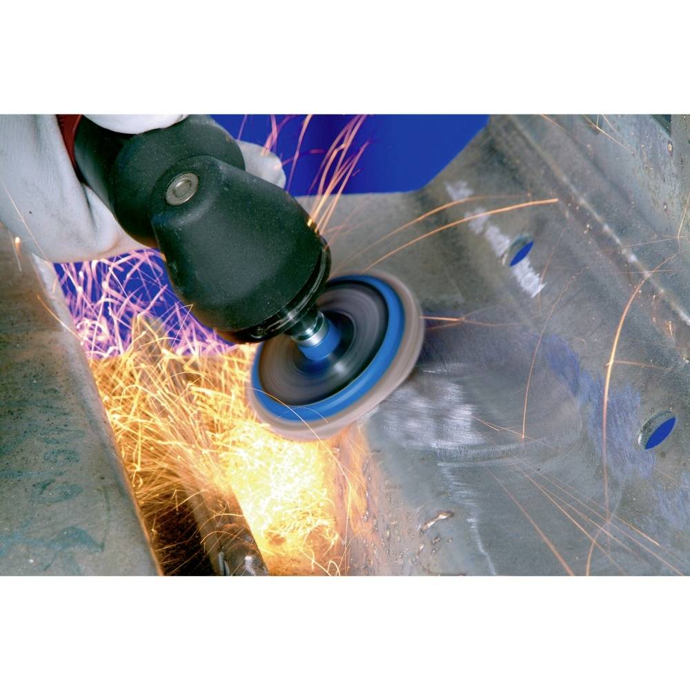 Eine Person schleift Metall mit einem Winkelschleifer. Funken sprühen vom bearbeiteten Metallstück ab.