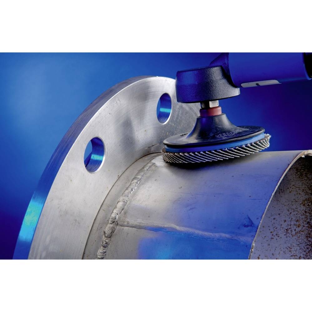 Eine Metallschleifmaschine glättet die Kante eines großen zylindrischen Metallstücks. Der Hintergrund ist blau beleuchtet.