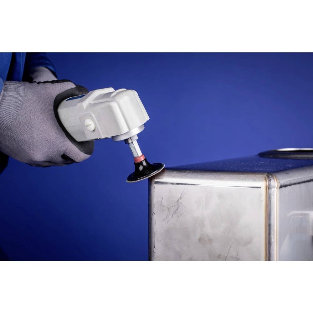 Eine Person schleift eine Metallkante mit einem Winkelschleifer, während sie Schutzhandschuhe trägt, vor einem blauen Hintergrund.