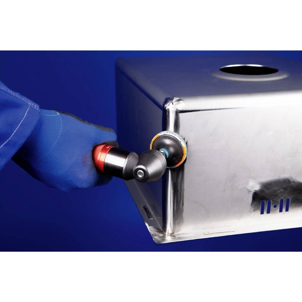 Eine Person schleift mit einem Elektrowerkzeug die Kante eines Metallbehälters. Die Person trägt blaue Arbeitshandschuhe.