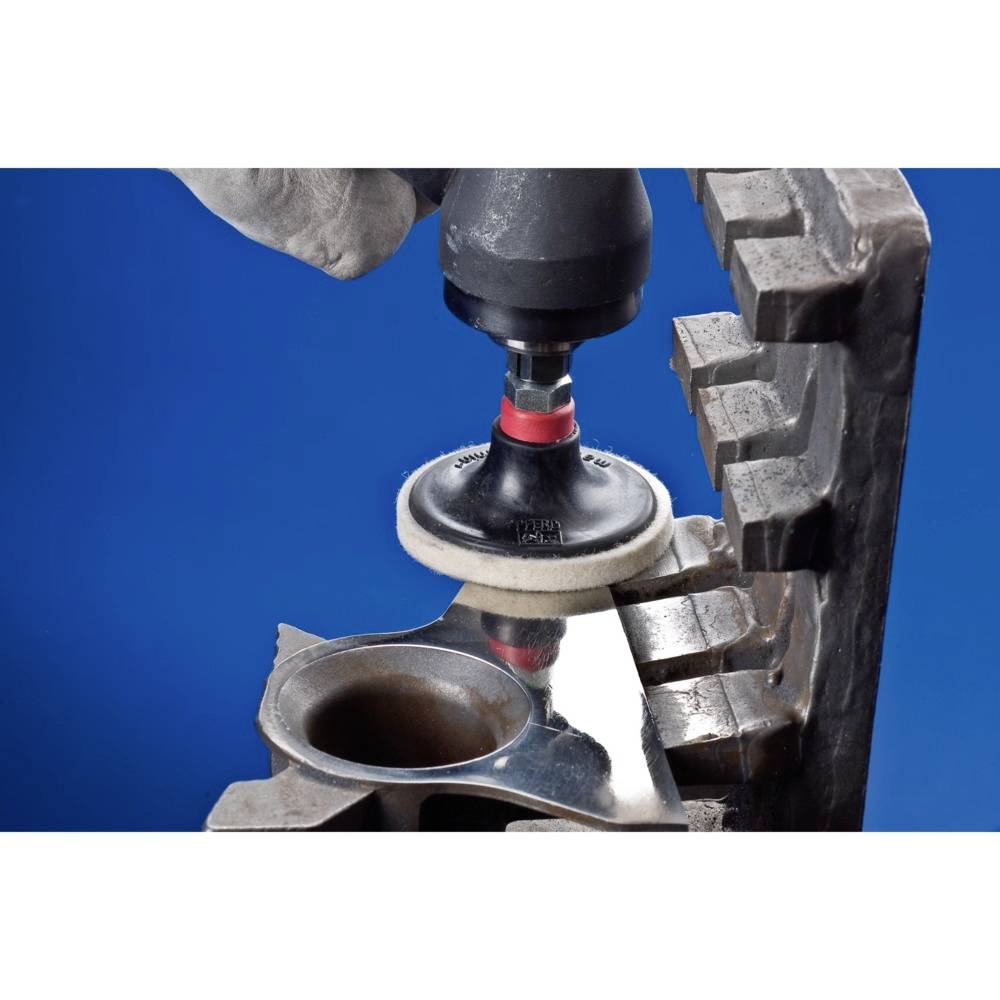 Metallpoliermaschine poliert eine Metalloberfläche, die von einer großen Klammer gehalten wird, vor einem blauen Hintergrund.