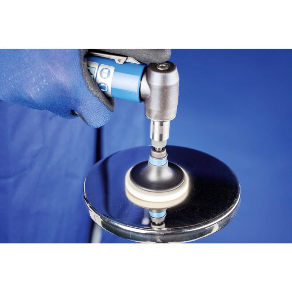 Eine Hand mit einem blauen Handschuh hält eine Poliermaschine, die eine silberne, runde Metalloberfläche poliert, vor einem blauen Hintergrund.