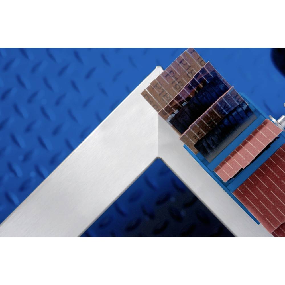 Metallplatte mit angewinkeltem Griff, daneben ein Stapel farbiger, rechteckiger Proben auf blauem Riffelblech-Hintergrund.