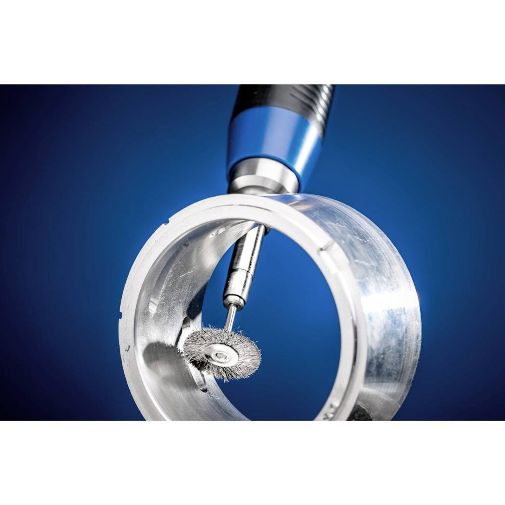 Ein rotierendes Werkzeug mit Drahtscheibe bearbeitet eine metallische, zylindrische Oberfläche vor blauem Hintergrund.