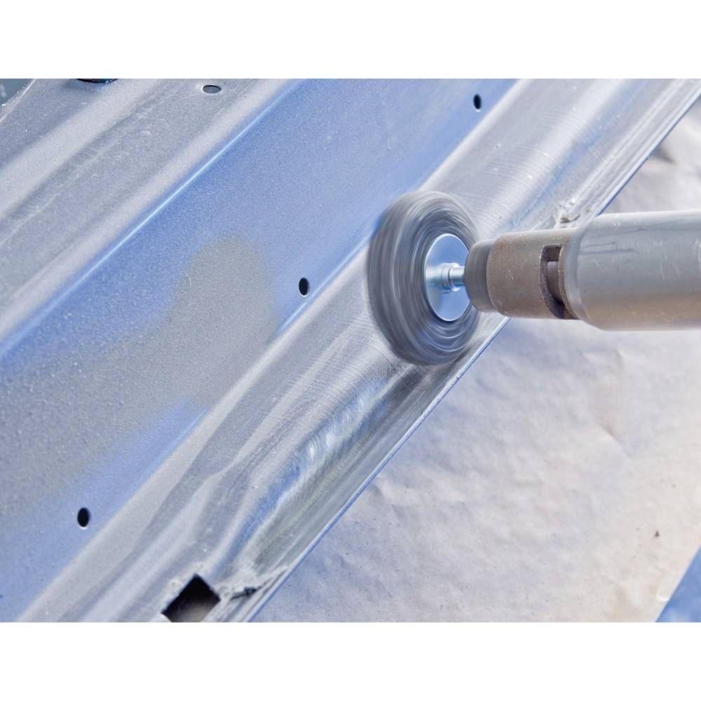 Ein Elektrowerkzeug schleift die Oberfläche eines Metallblechs, wodurch eine glatte und glänzende Oberfläche entsteht.