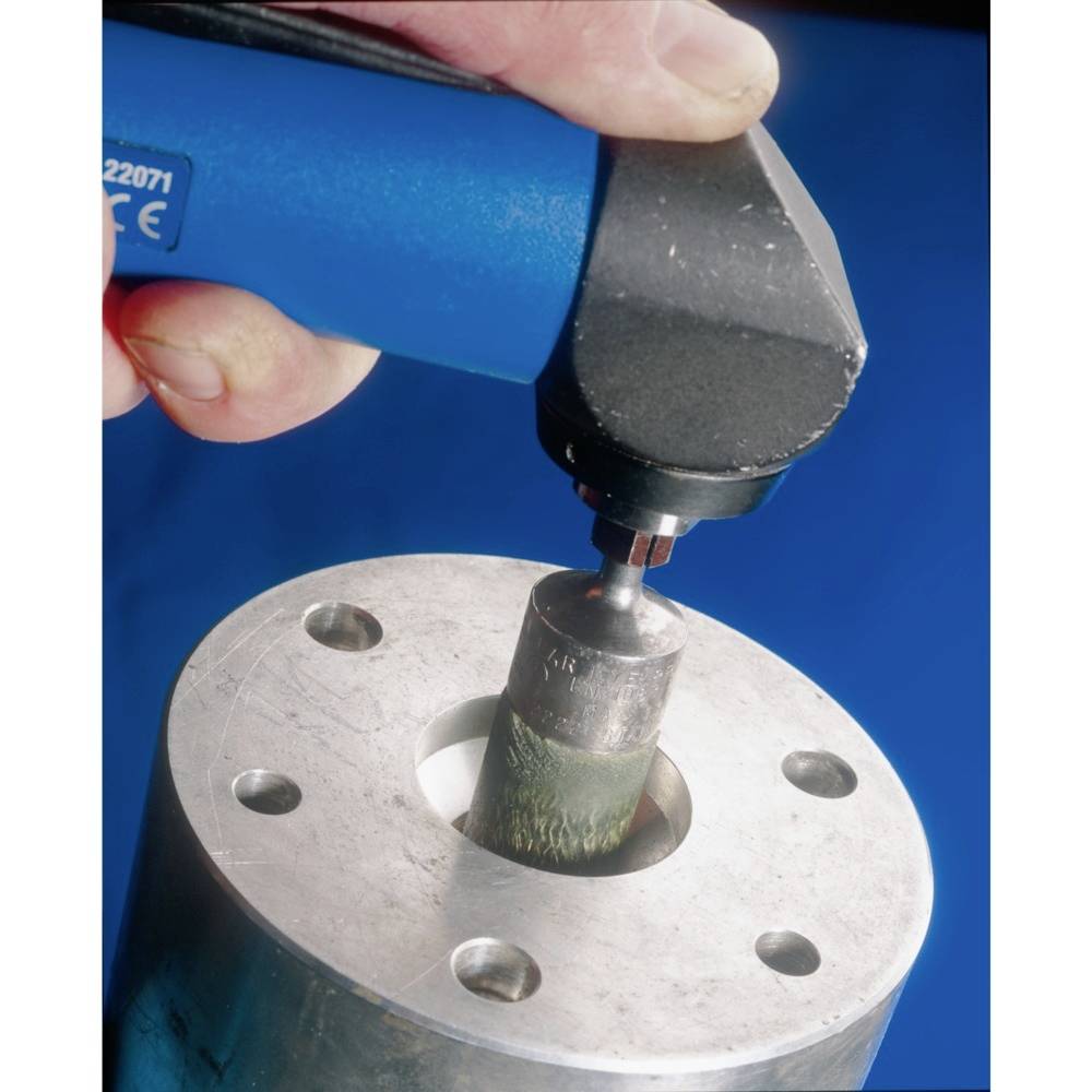 Eine Hand hält ein tragbares Elektrogerät, um eine Metalloberfläche mit einer rotierenden Scheibe glatt zu schleifen.