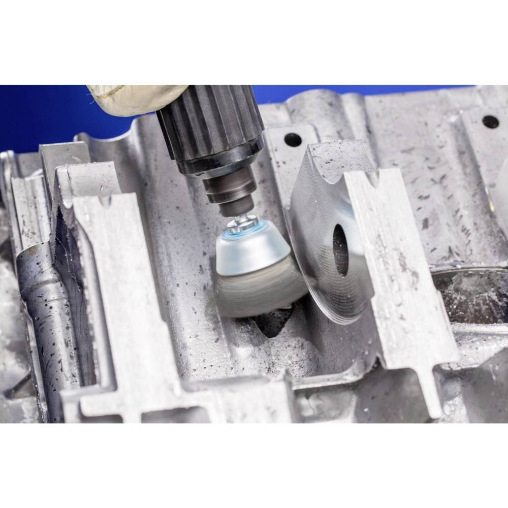 Eine metallische Oberfläche wird mit einer rotierenden Schleifmaschine bearbeitet, um sie zu polieren oder zu glätten.