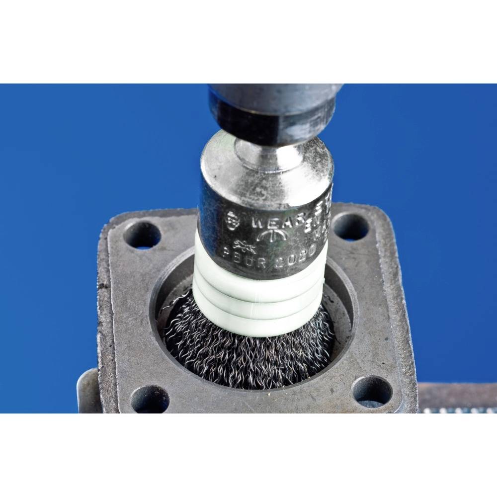 Nahaufnahme einer rotierenden Drahtbürste, die ein metallisches Innengewinde reinigt. Der Hintergrund ist blau.