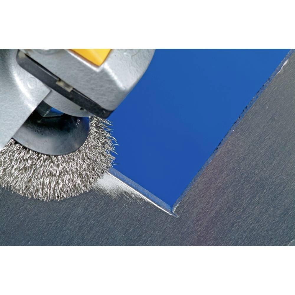 Eine Drahtbürste poliert einen blauen Metallwinkel, erzeugt Funken und verleiht der Oberfläche einen glatten, glänzenden Abschluss.