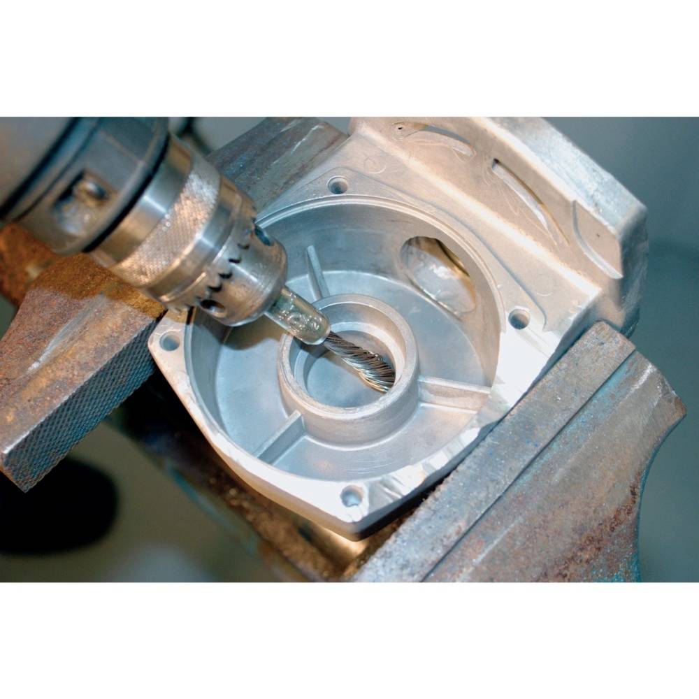 Eine Metallfräse bearbeitet ein rundes Metallteil, das in einem Schraubstock befestigt ist. Der Fräskopf dreht sich schnell.