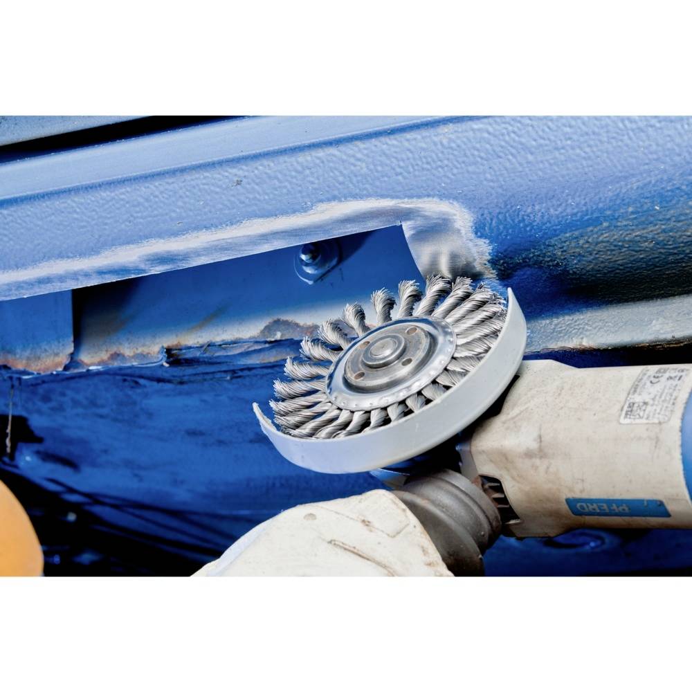 Schleifwerkzeug bearbeitet Metallfläche, entfernt Rost und Anstrich. Detailansicht eines Arbeitsschritts, Elektroschleifer im Einsatz.