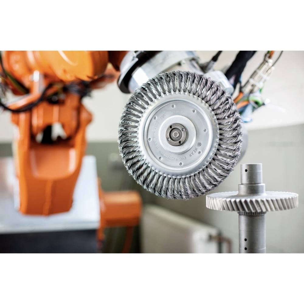 Industrieroboter mit Schleifwerkzeug bearbeitet ein Zahnrad, zeigt moderne Fertigungstechnik in einer Fabrikumgebung.