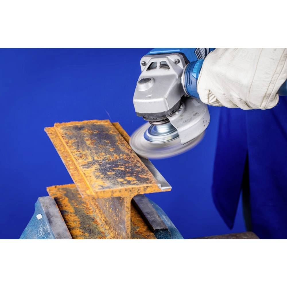 Eine Person entfernt mit einem Winkelschleifer Rost von einem Metallstück. Die Person trägt Schutzhandschuhe, der Hintergrund ist blau.