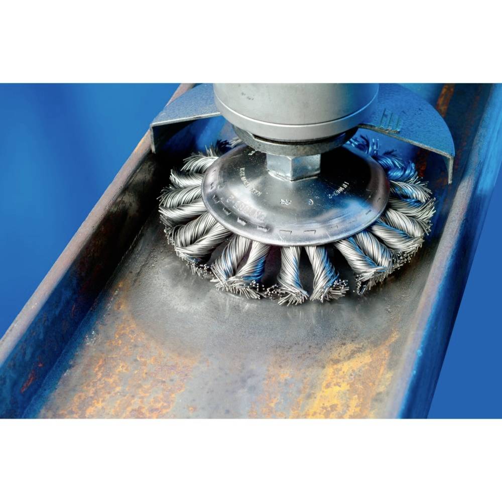 Eine rotierende Drahtbürste bearbeitet die Oberfläche eines Metallträgers, entfernt Rost und reinigt die Oberfläche.