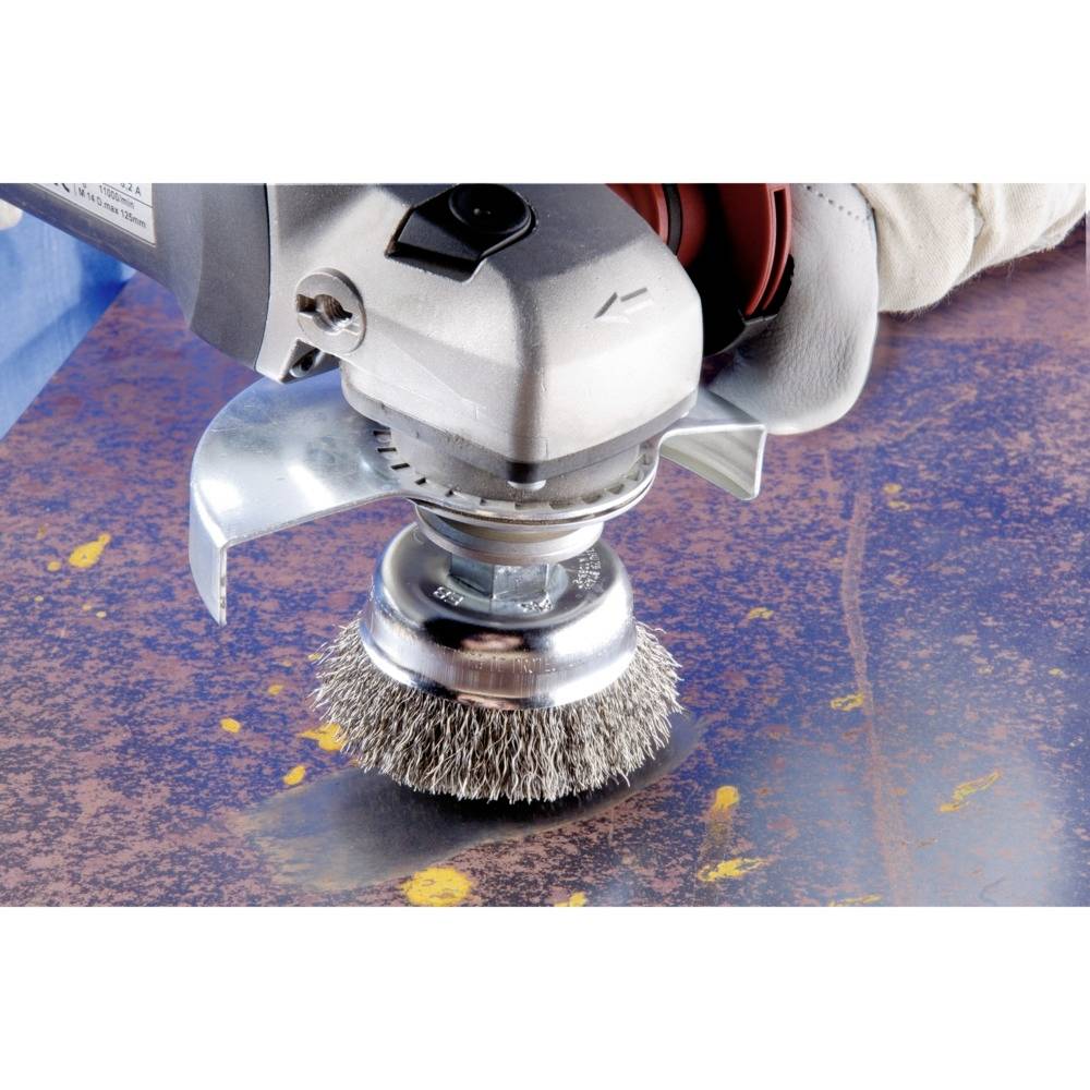 Eine Drahtbürste auf einem Elektrowerkzeug entfernt Rost von einer Metalloberfläche.