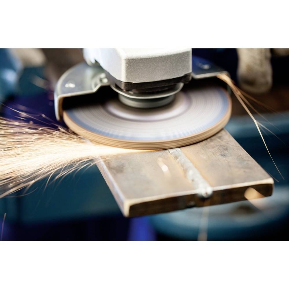 Eine Schleifmaschine bearbeitet eine Metallplatte, während Funken fliegen. Dies zeigt einen aktiven Bearbeitungsprozess in einer Werkstattumgebung.