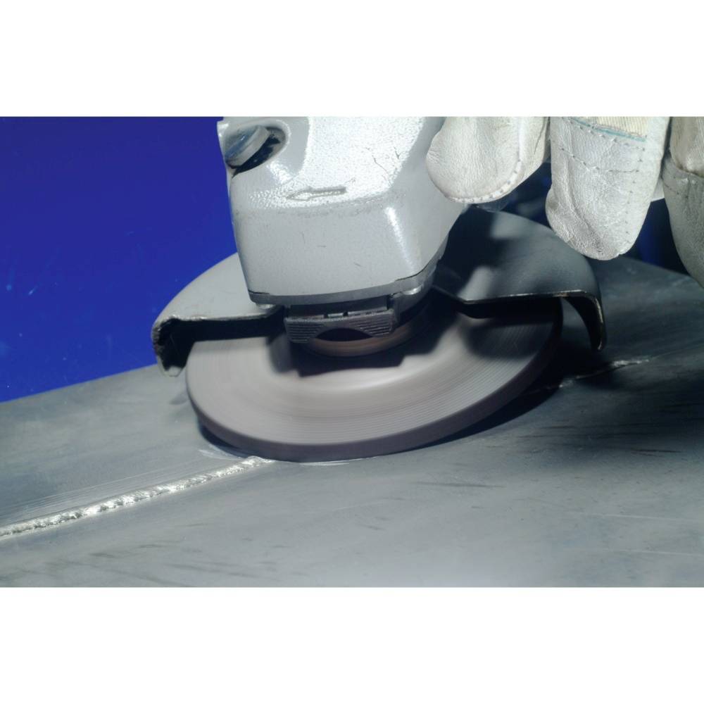 Arbeiter mit Schleifmaschine glättet metallische Oberfläche, Tragen von Schutzhandschuhen.