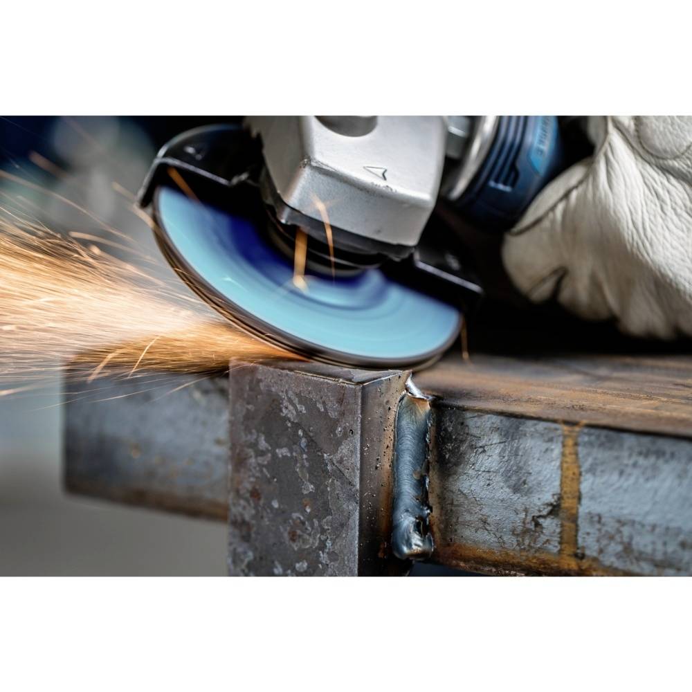 Ein Winkelschleifer schneidet mit blauer Scheibe durch ein Metallstück, Funken fliegen vom Kontaktpunkt. Handschuh hält Werkzeug.
