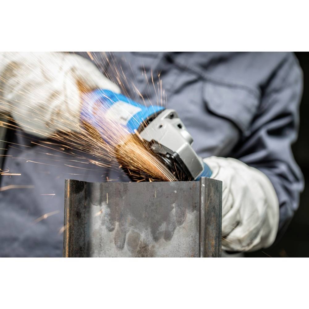 Ein Arbeiter in Schutzkleidung schleift Metall mit einem Winkelschleifer. Funken fliegen vom Schleifvorgang.