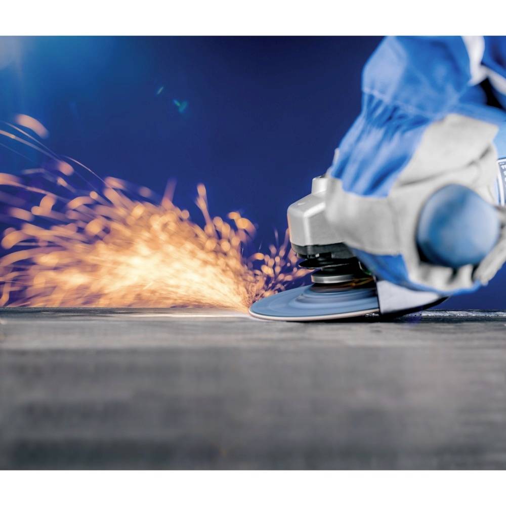 Eine Person verwendet einen Winkelschleifer, der Funken erzeugt. Schutzhandschuhe und -kleidung werden getragen, blaue Farbdetails sind sichtbar.