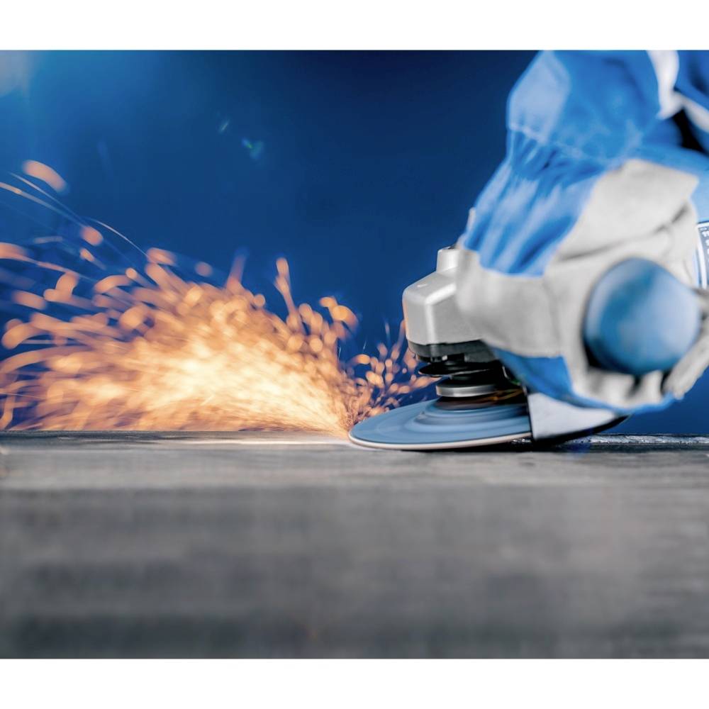 Eine Person in blauen Arbeitshandschuhen schleift Metall mit einem Winkelschleifer, Funken fliegen nach links.
