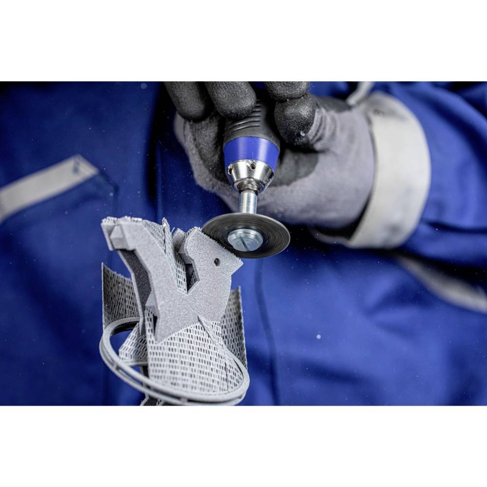 Eine Person in Arbeitskleidung bearbeitet ein industrielles Metallteil mit einem Schleifwerkzeug.