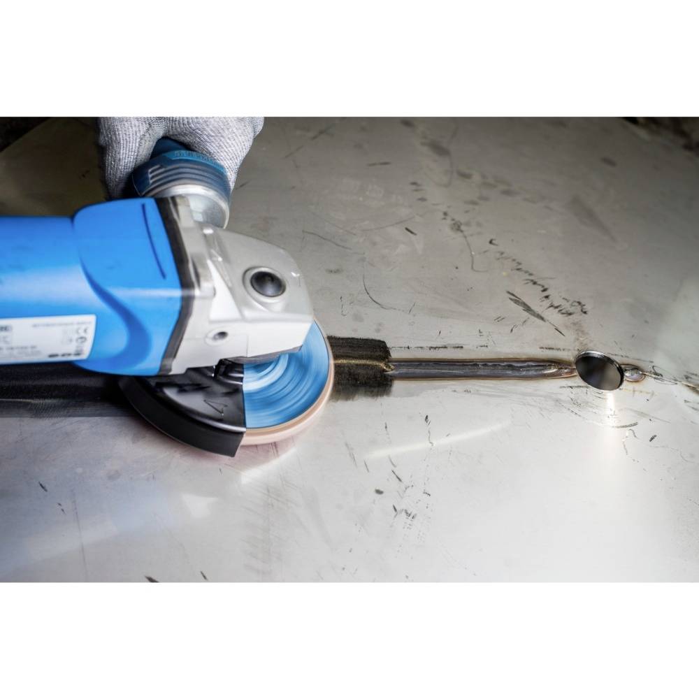 Eine Person schleift mit einer blauen Schleifmaschine Metall. Funken fliegen links aus der Schleifstelle, Hand in Schutzhandschuh.