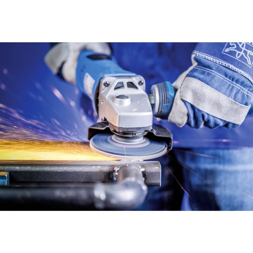 Eine Person trägt Schutzhandschuhe und verwendet eine Schleifmaschine, aus der Funken beim Bearbeiten eines Metallstücks sprühen.