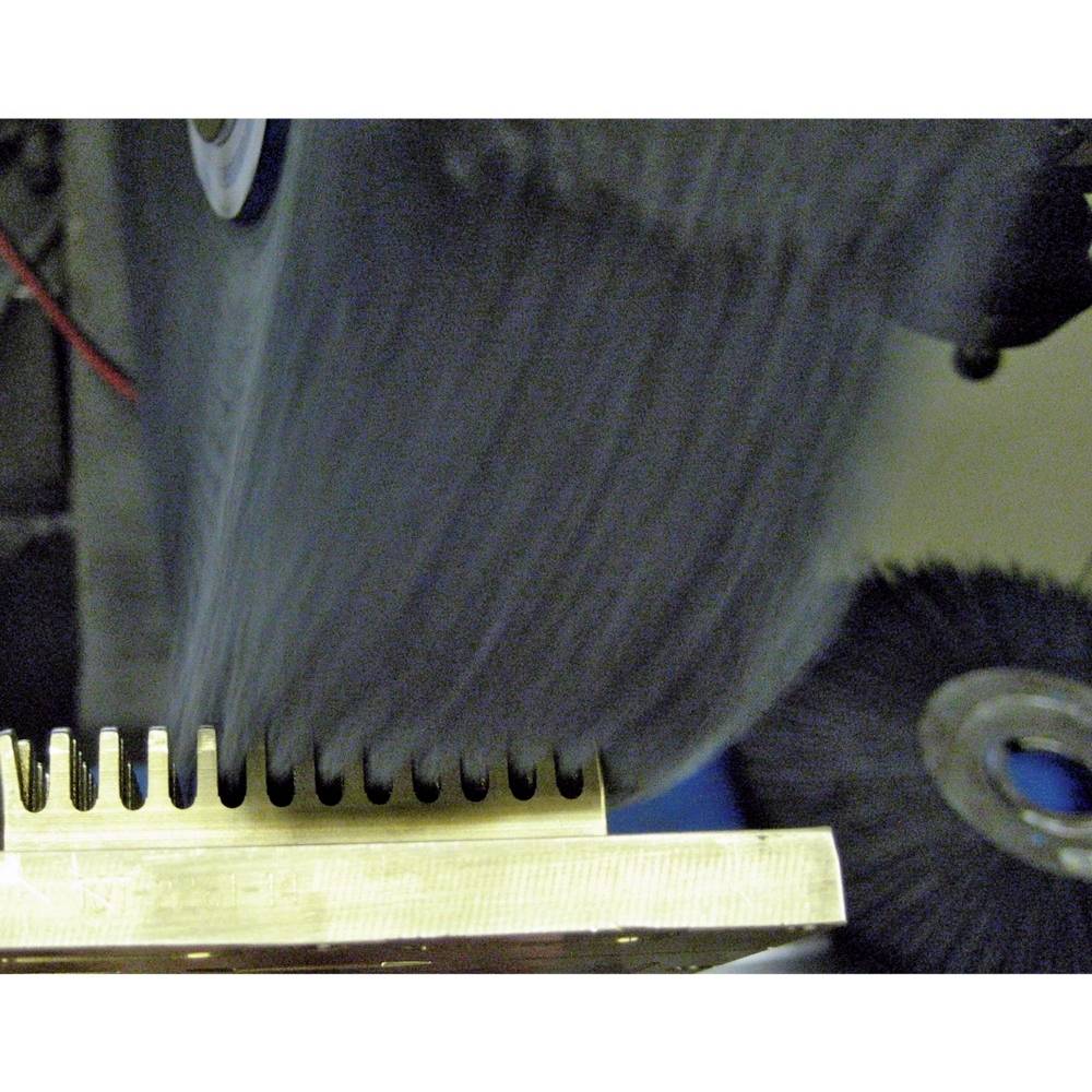 Ein metallischer Gegenstand wird von einer rotierenden Schleifscheibe poliert. Funken und Bewegungsunschärfe sind sichtbar.