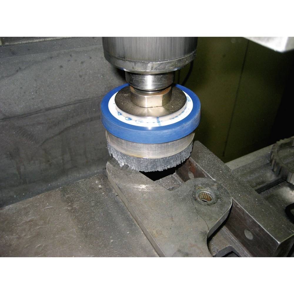 Eine Metallverarbeitungsmaschine mit rotierendem Werkzeug bearbeitet ein Metallstück, um eine präzise Oberfläche zu erzeugen.