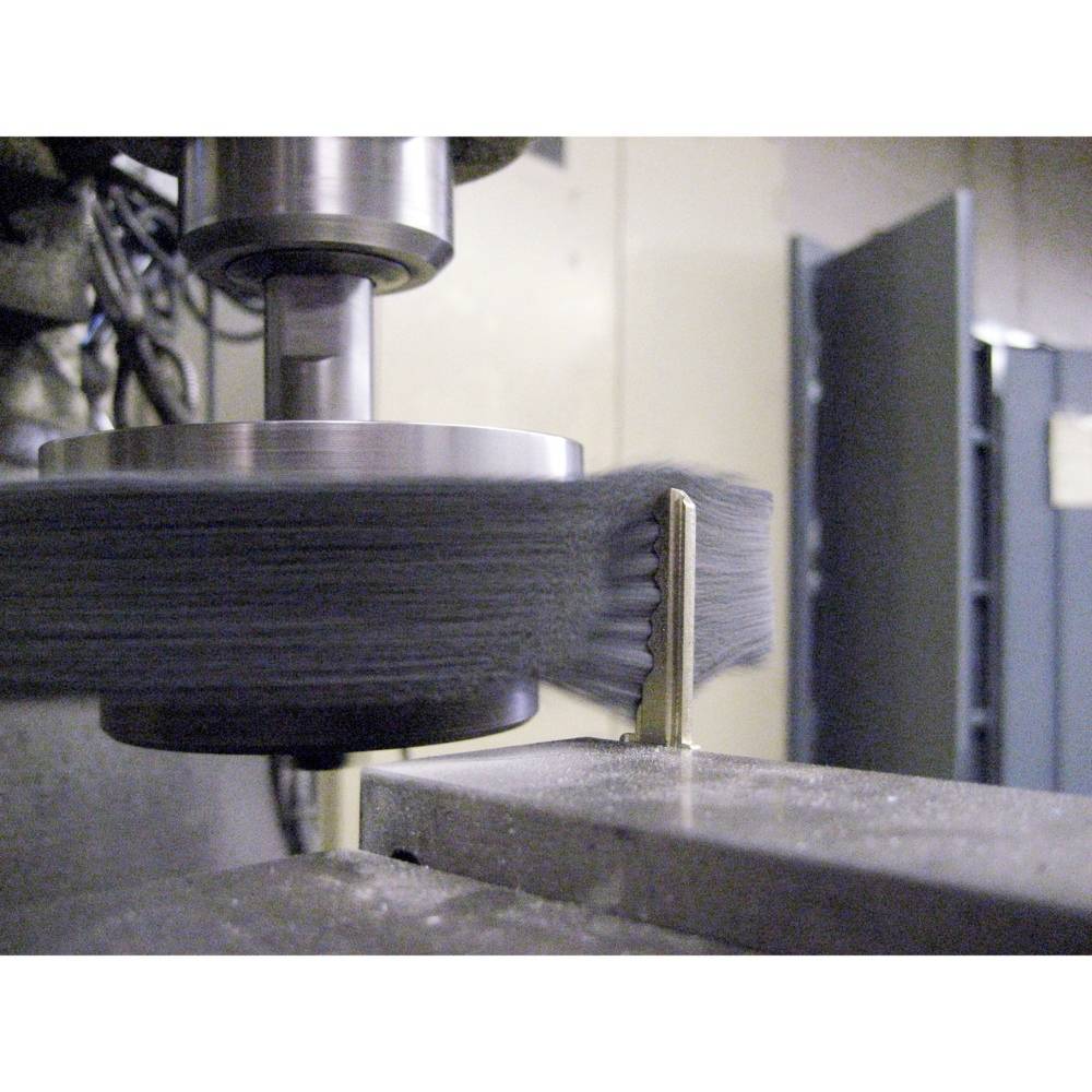 Eine Metallfräsmaschine arbeitet an einem Werkstück. Die Fräse rotiert schnell, sichtbare Metallspäne zeugen von aktiver Bearbeitung.