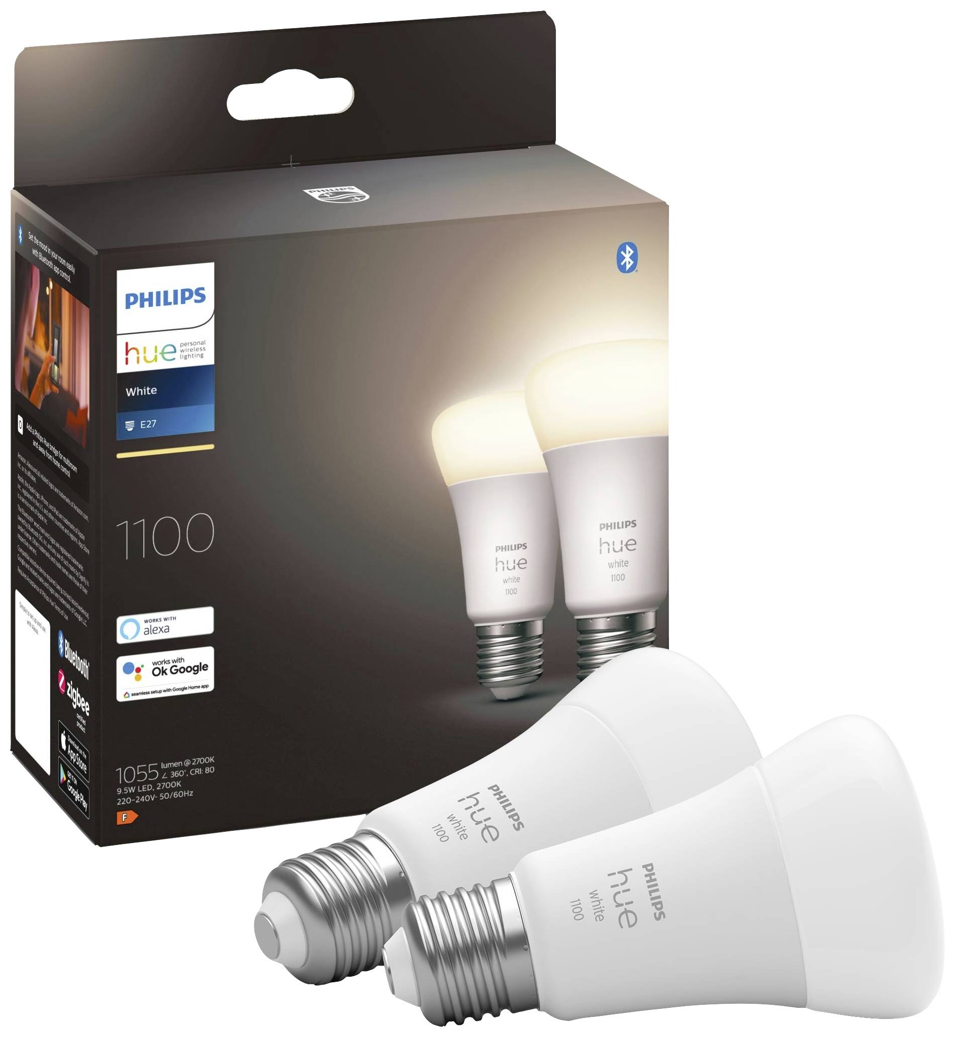 Zwei Philips Hue-LED-Glühbirnen vor der Produktverpackung. Verpackung zeigt Markenlogo und Kompatibilität mit Sprachassistenten.