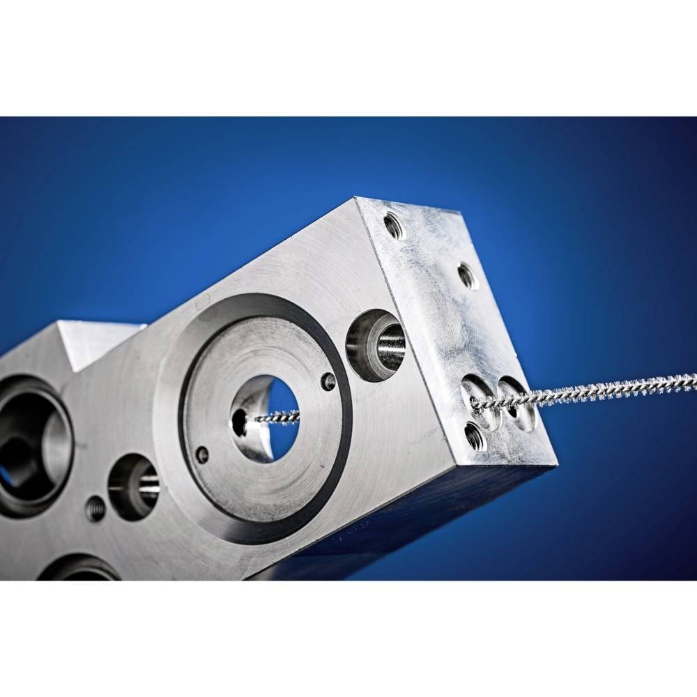 Metallblock mit mehreren runden Aussparungen und einem durchgeführten Kabel vor blauem Hintergrund, technische Darstellung.