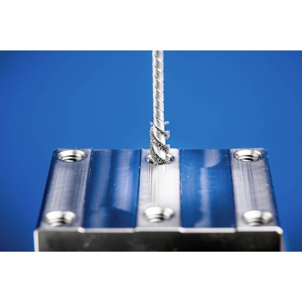 Ein Bohrer durchdringt ein rechteckiges Metallstück, während Metallspäne sich um den Bohrer wickeln. Hintergrund in Blau gehalten.