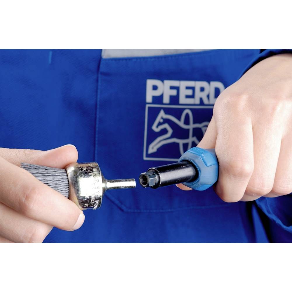 Zwei Hände halten ein Werkzeugteil und einen Adapter vor einer blauen Schürze mit dem Logo 'PFERD'.
