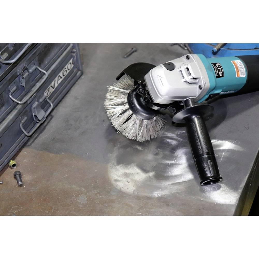 Eine elektrische Schleifmaschine mit einer Bürstenaufsatz wird verwendet, um eine Metallfläche zu bearbeiten. Ein Werkzeugkasten steht daneben.