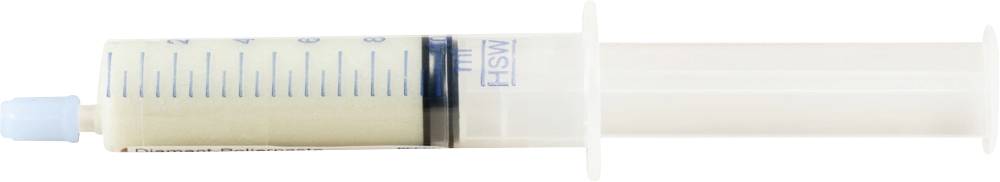 Eine weiße Spritze mit Skala und blauer Kappe, halb gefüllt mit einer cremefarbenen Substanz.