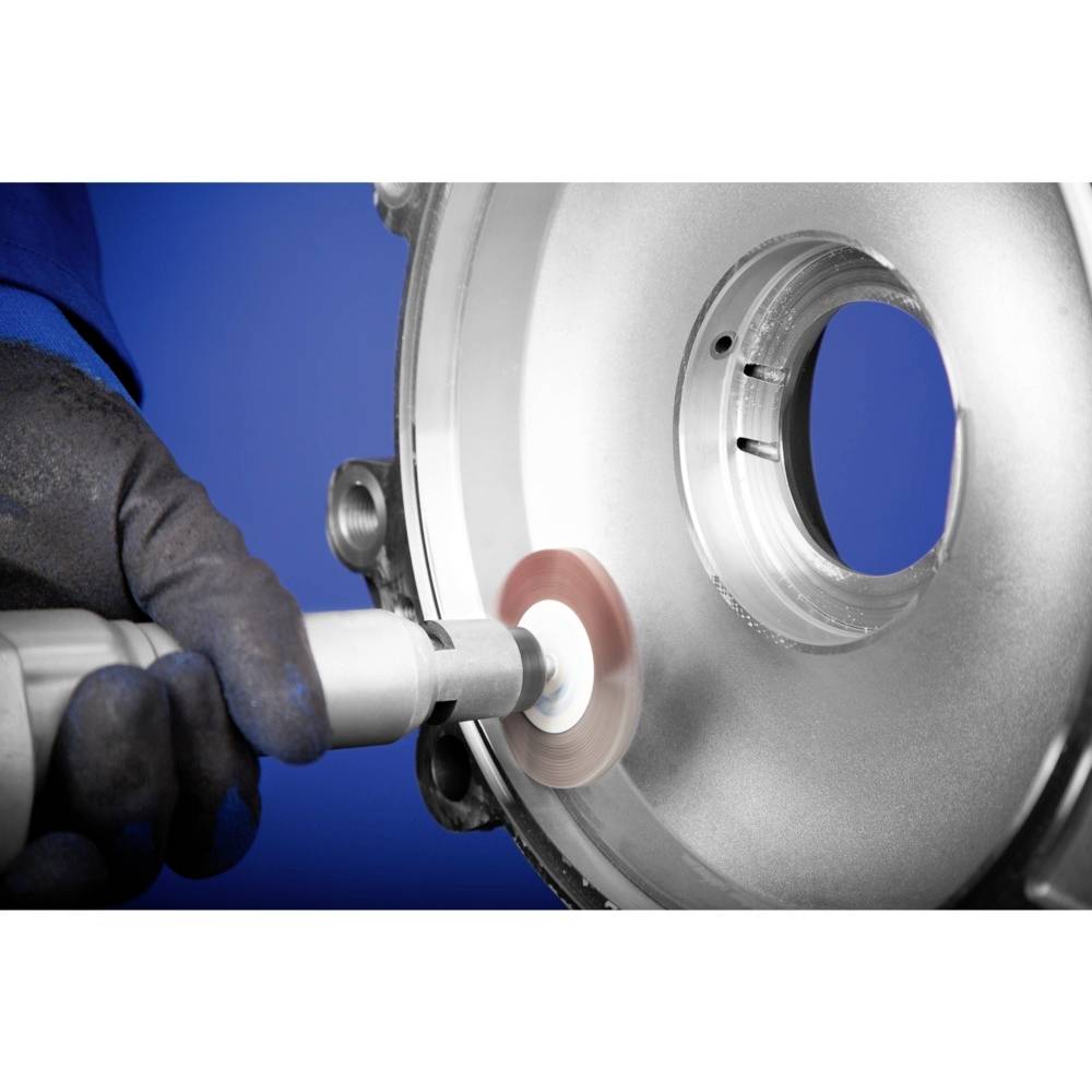 Ein Arbeiter mit blauen Handschuhen poliert eine metallische Scheibe mit einem elektrischen Werkzeug. Die Umgebung ist blau.