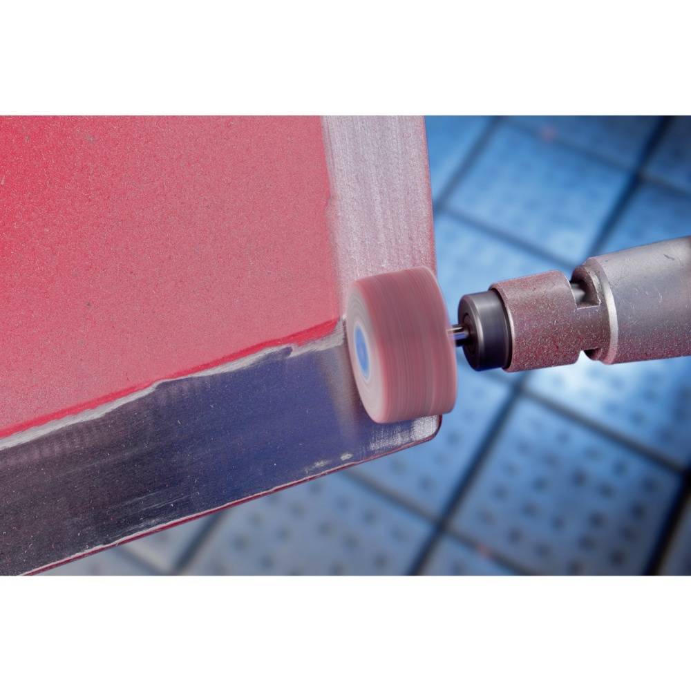 Eine Nahaufnahme eines Werkzeugs, das einen rot lackierten Metallrand schleift. Im Hintergrund verschwommene, blaue Fliesen.