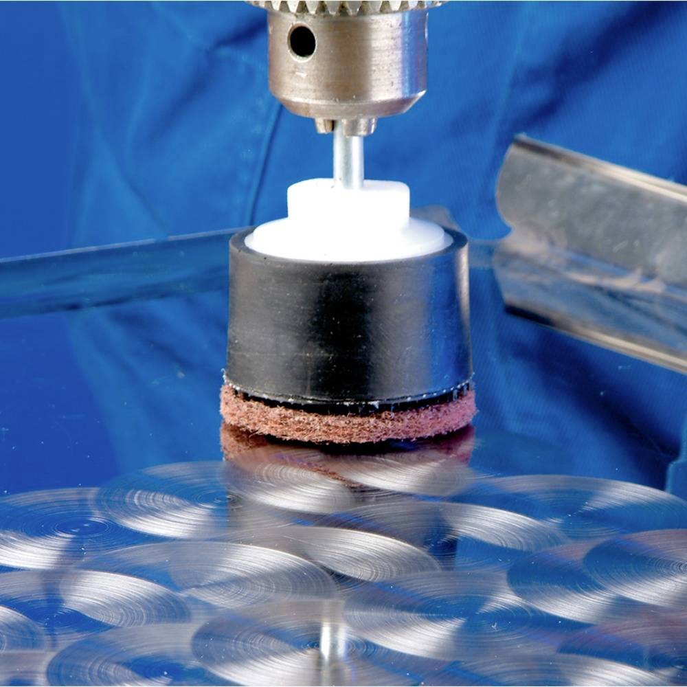 Nahaufnahme eines Rotationsschleifers auf einer Metalloberfläche. Der Schleifer entfernt Kratzer, erzeugt ein glänzendes Finish.