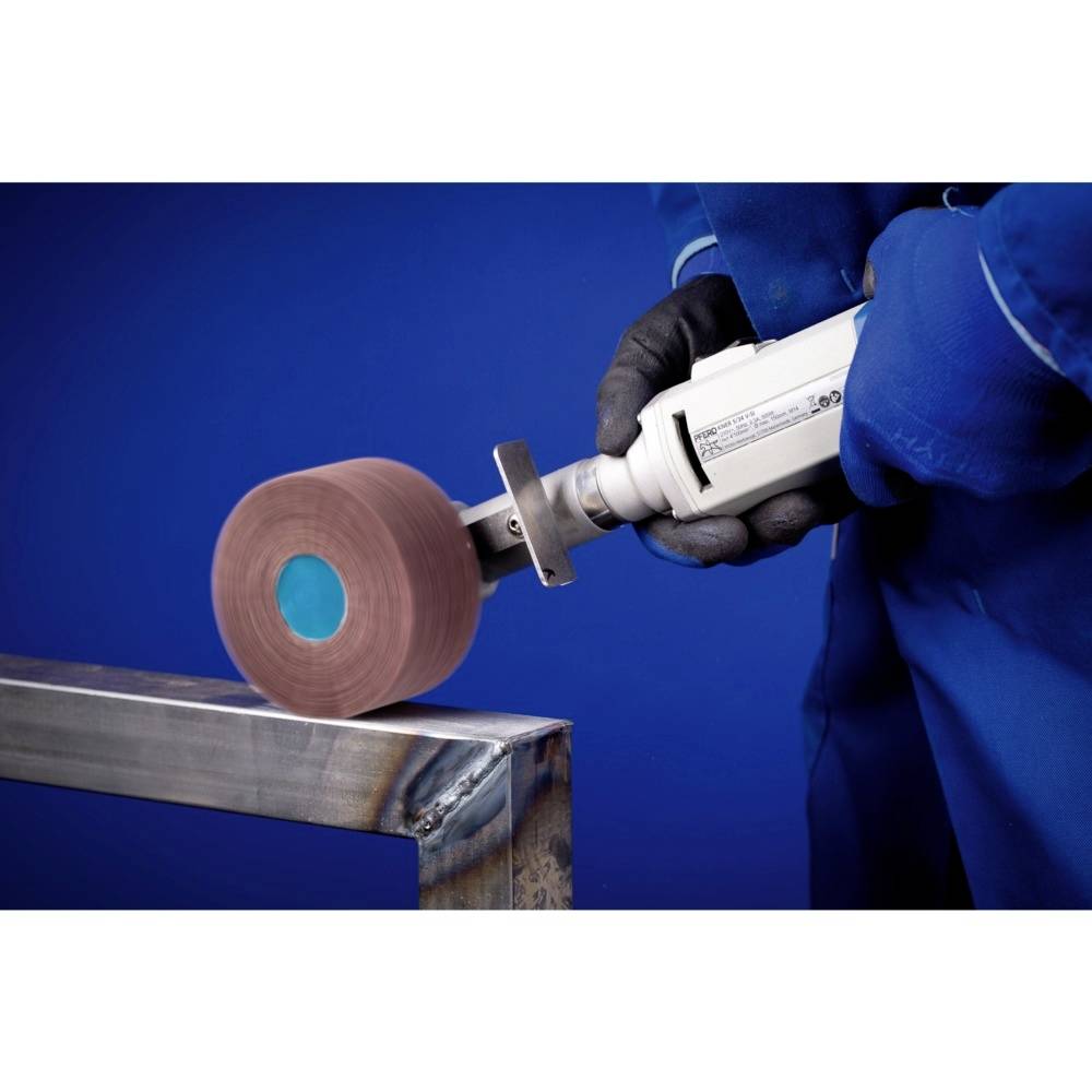 Eine Person schleift mit einem elektrischen Schleifgerät metallische Oberfläche. Arbeitet präzise; trägt blaue Schutzkleidung und Handschuhe.