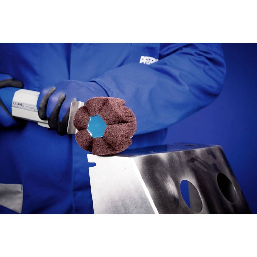 Eine Person in blauer Arbeitskleidung benutzt ein Polierwerkzeug auf einem metallischen Objekt, um die Oberfläche zu glätten.