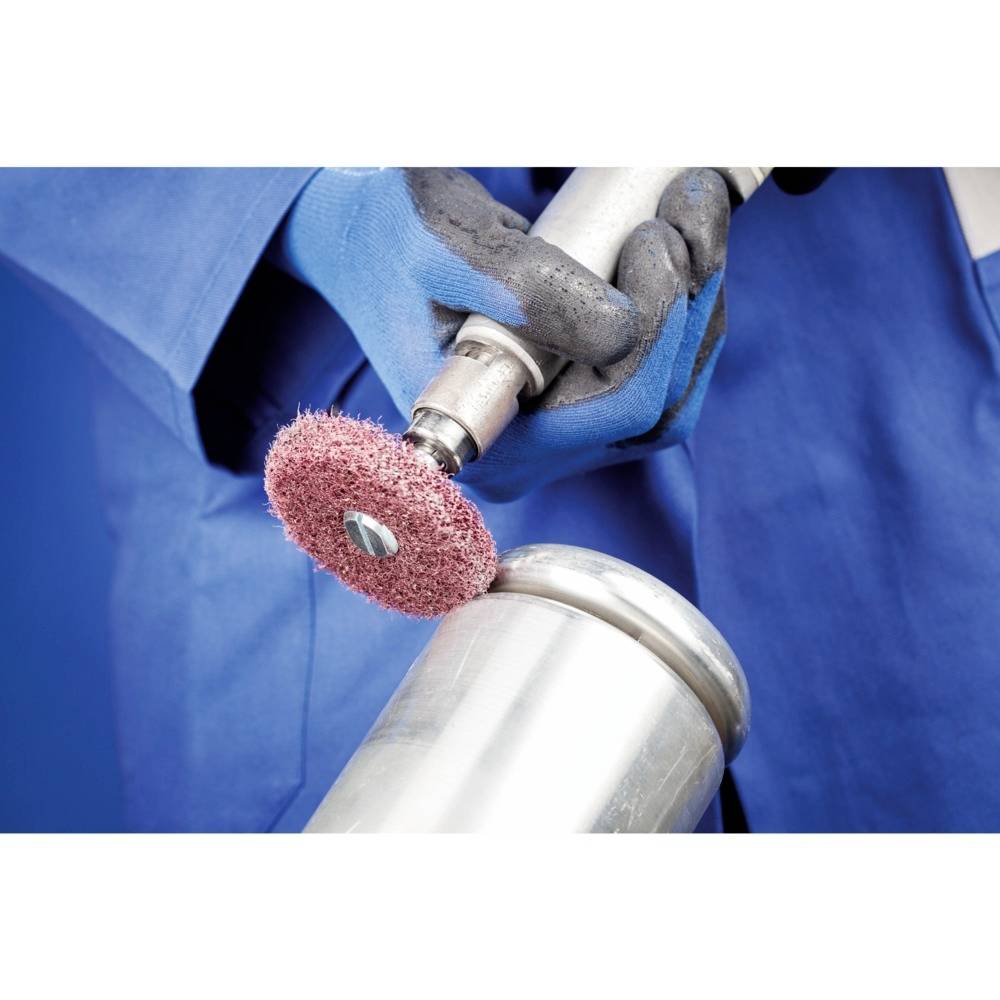 Hand in blauen Handschuhen hält und benutzt eine Metallpoliermaschine mit einer rotierenden Bürste auf einem Metallzylinder.