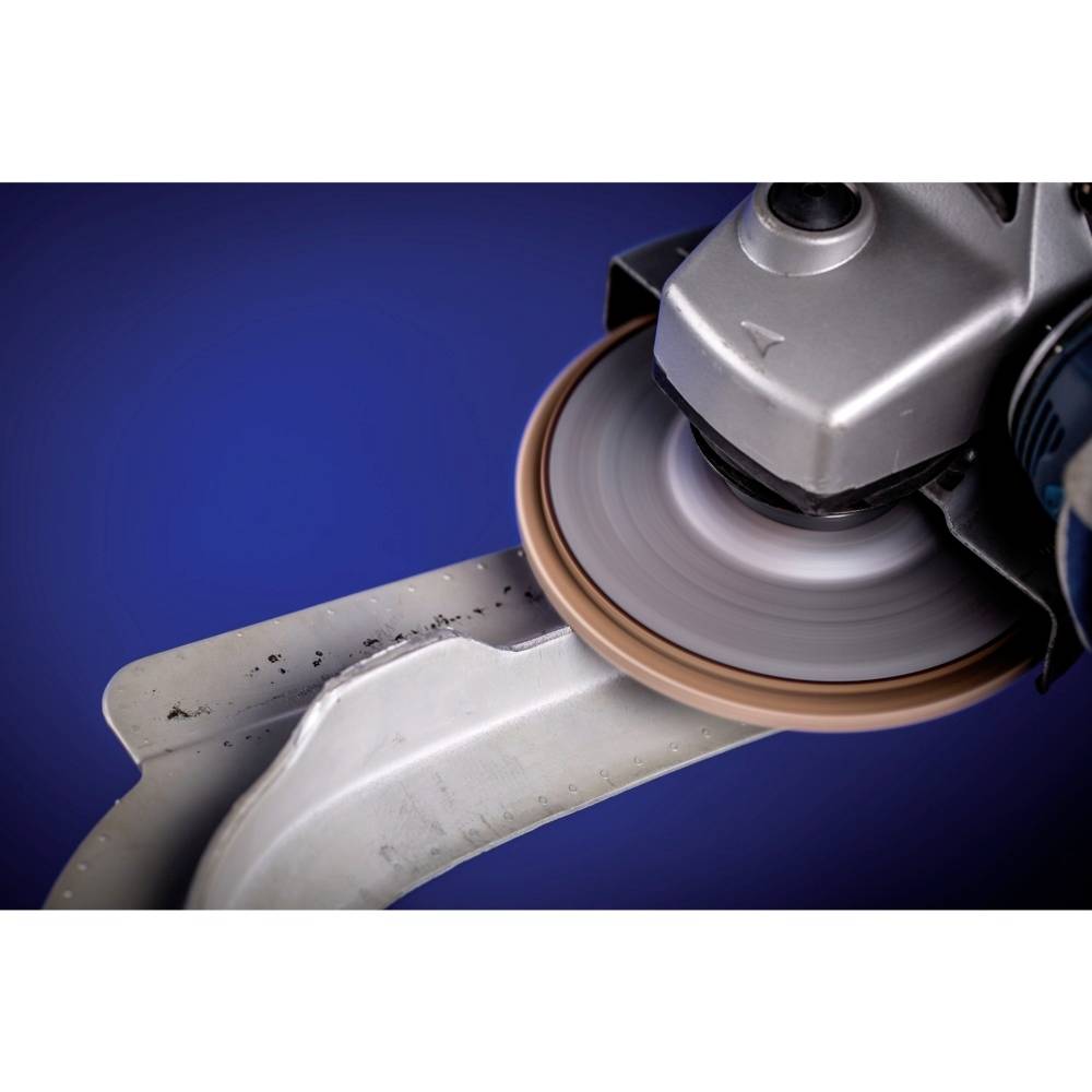 Nahaufnahme eines Winkelschleifers, der an einem Metallstück arbeitet. Die Schleifscheibe rotiert schnell und erzeugt Funken.