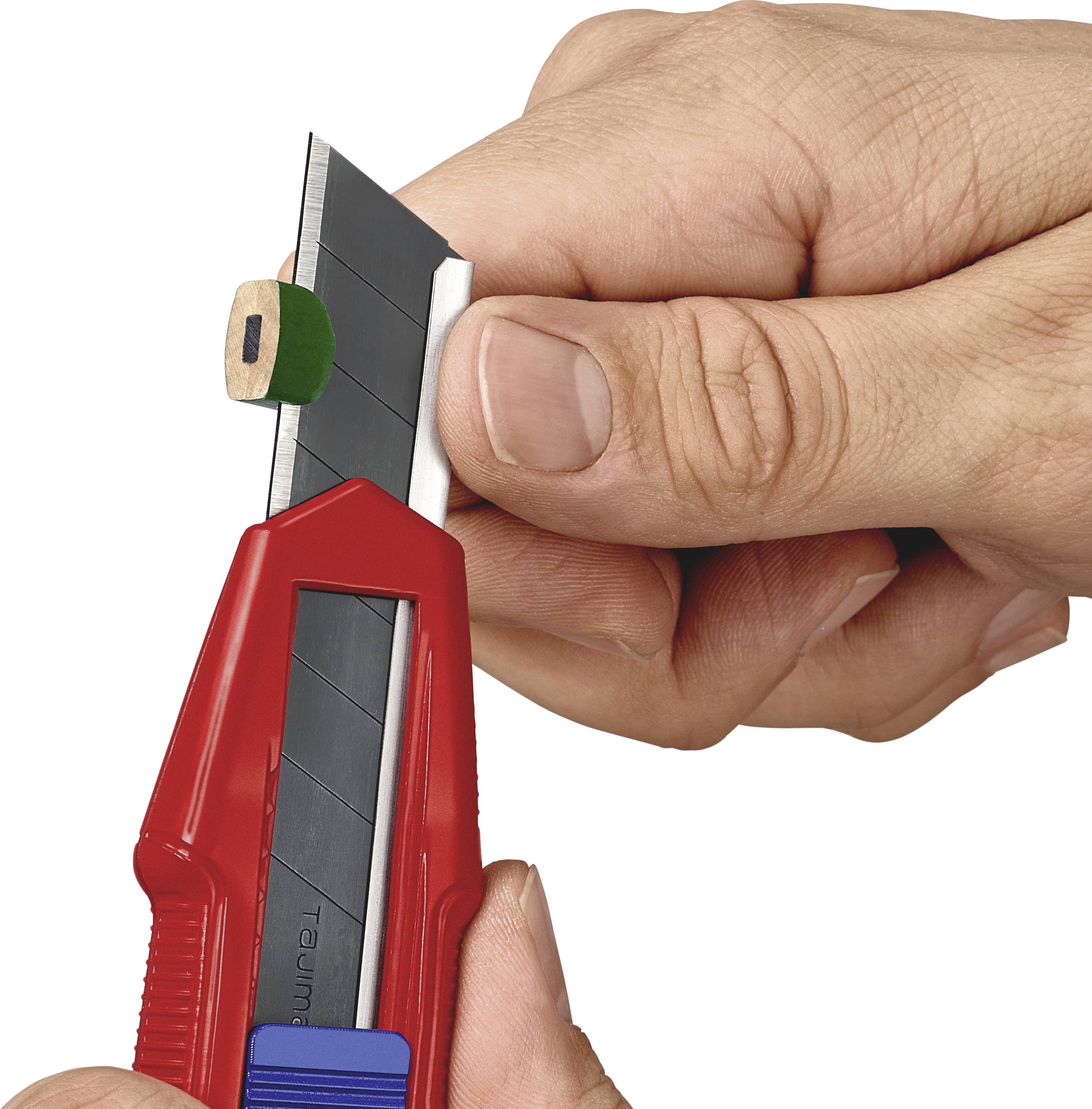 Eine Hand hält ein rotes Teppichmesser und schneidet ein kleines Holzstück, das auf einem Finger liegt.
