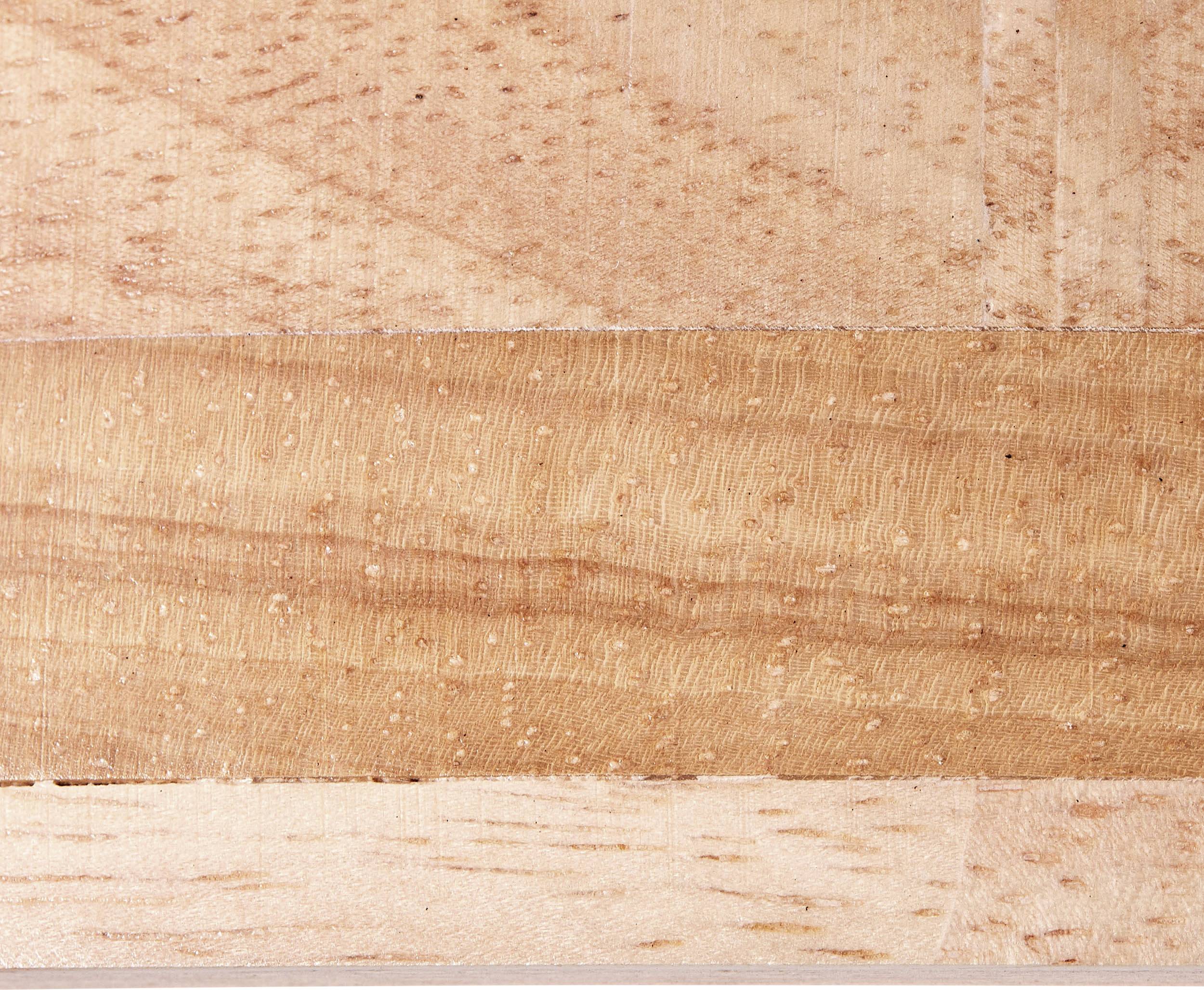 Nahaufnahme von Holzoberfläche mit unterschiedlichen Maserungen und Farbtönen, die eine natürliche, strukturierte Optik bietet.