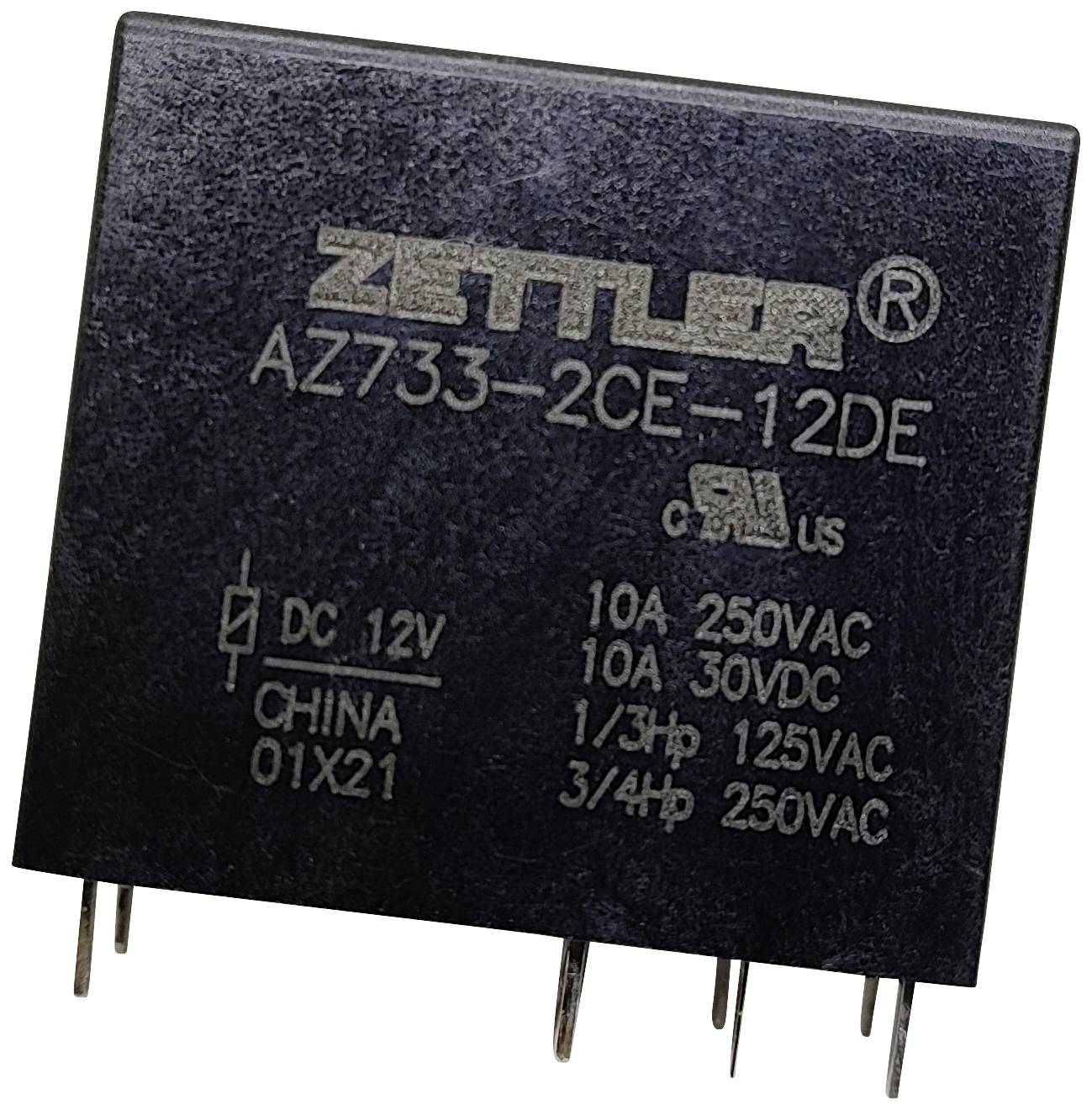 Ein schwarzes Relais mit der Aufschrift 'Zettler AZ733-2CE-12DE'. Es hat mehrere technische Spezifikationen zu Spannung und Stromstärke.